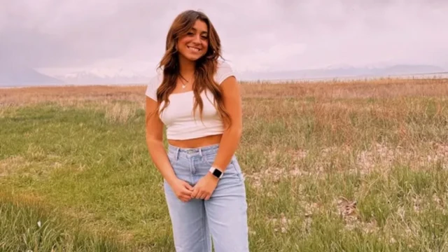Caroline sorrindo em frente a um gramado