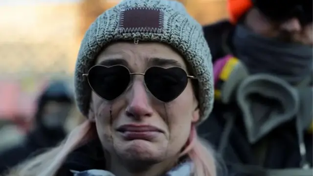 One woman dey cry as pipo gada around one makeshift memorial close to wia dem shoot Alex Pretti