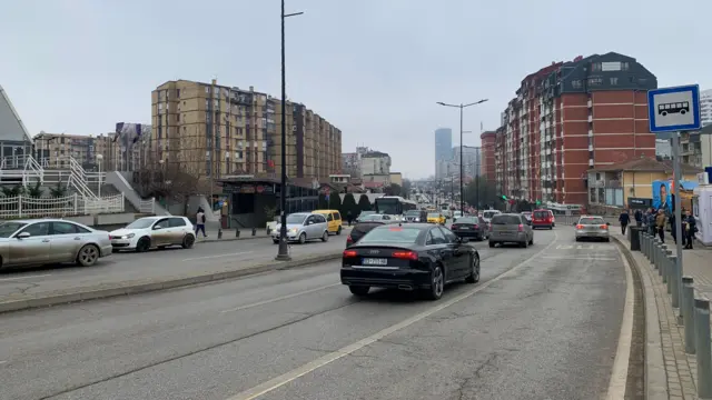Automobili na ulici u daljini nekoliko stambenih zgrada