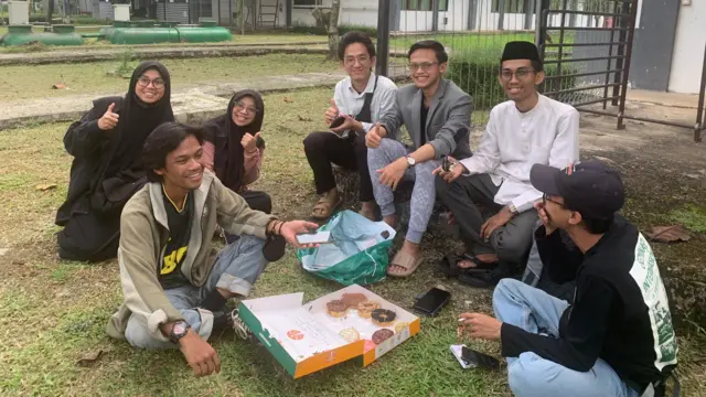 Muhammad Mufid memakan kue donat bersama dengan mahasiswa-mahasiswa WNI lainnya yang berhasil dievakuasi dari Khartoum, Sudan pada Jumat (28/4)