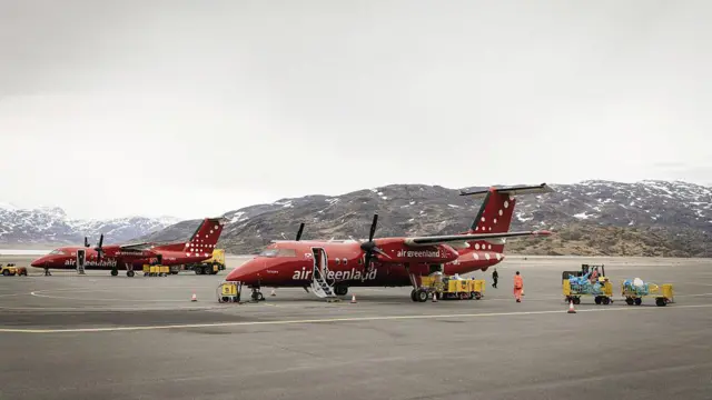 Два небольших красных самолета Air Greenland на аэродроме.
