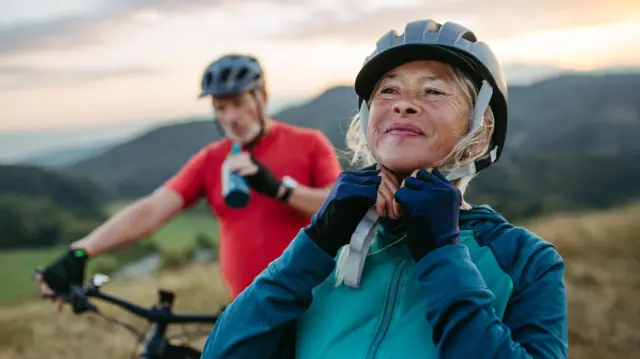 Retrato de una pareja mayor paseando en bicicleta por la naturaleza  
