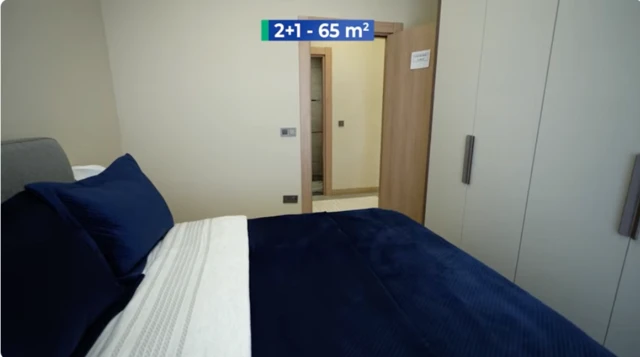 Bir evin odasında yatak, gardrop ve odanın kapısı görülüyor