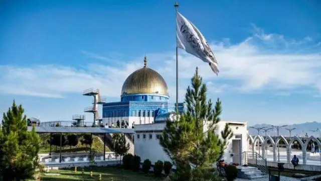 या फोटोत एका इमारतीवर पांढरा झेंडा फडकताना दिसत आहे.