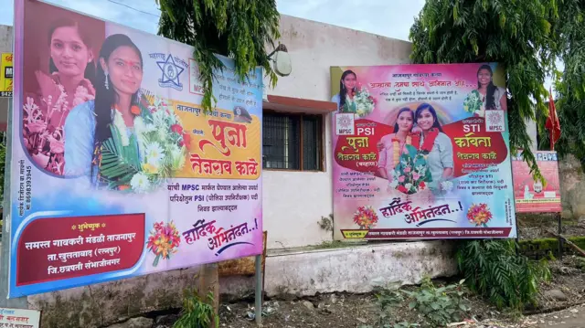 पूजा आणि कविता यांच्या अभिनंदनाचे गावात लागलेले बॅनर.