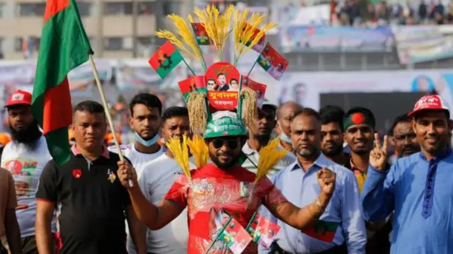 বিএনপির একজন কর্মীর হাতে দলীয় পতাকা ও নির্বাচনী প্রতীক