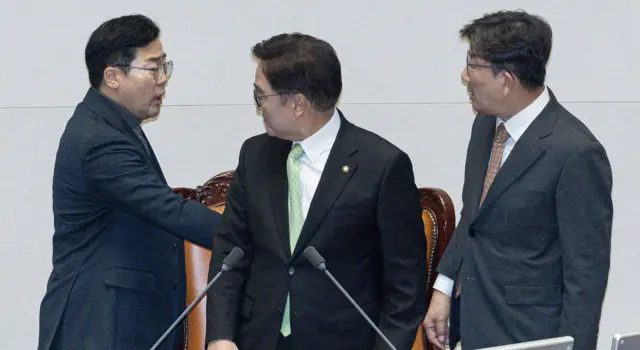 더불어민주당 박찬대 원내대표와 국민의힘 권성동 원내대표가 우원식 국회의장석 뒤에서 언쟁을 벌이고 있다