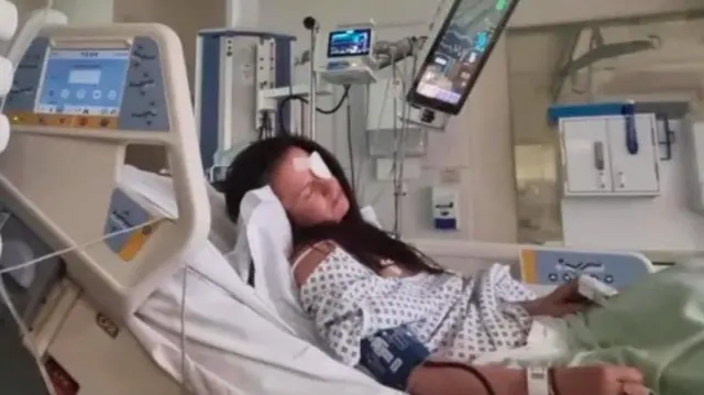 Kaylie com tapa-olho deitada no leito de um hospital