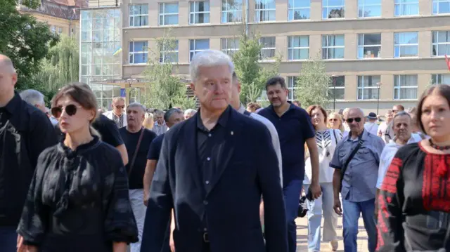 Петро Порошенко йде вулицею в оточенні своїх однопартійців. Ліворуч його дружина Марина Порошенко