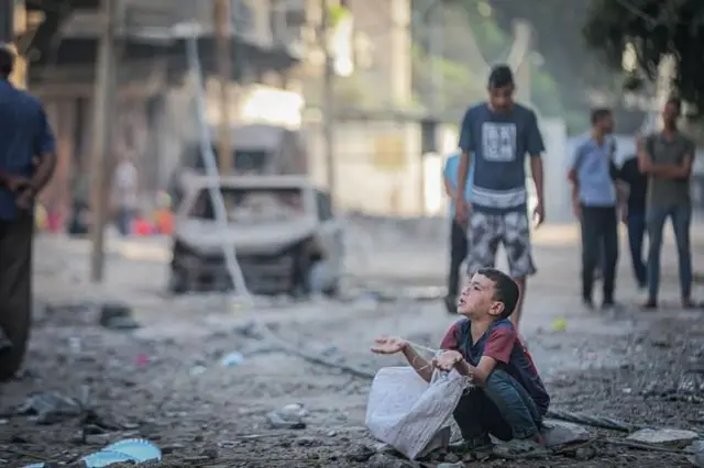 দুর্ভিক্ষ পীড়িত গাজার একটি শিশু সাহায্য চাইছে।