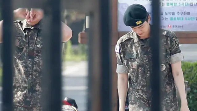 군 장병과 인사를 나눈 BTS 진이 부대 문을 향해 걸어나오고 있다 