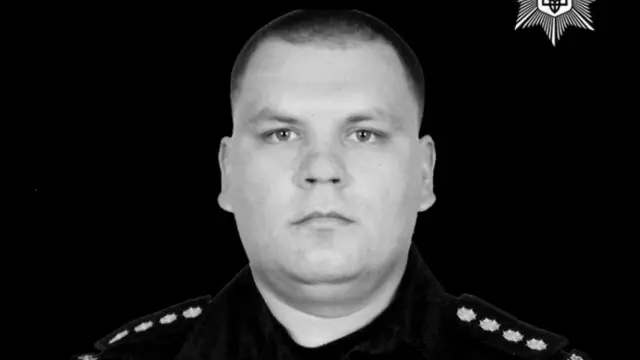 Чоловік у формі поліції на чорнмоу фоні 