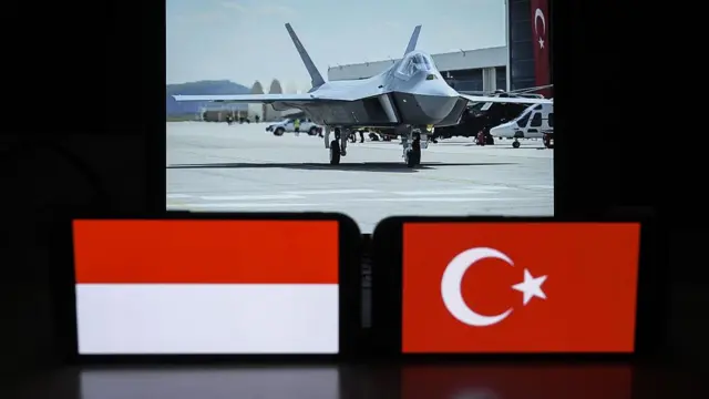 ANKARA, TURKI - 11 JULI: Dalam ilustrasi foto ini, bendera Turki dan Indonesia, yang terpampang di layar ponsel di depan pesawat tempur nasional Turki KAAN, terlihat di Ankara, Turki, pada 10 Juli 2024.