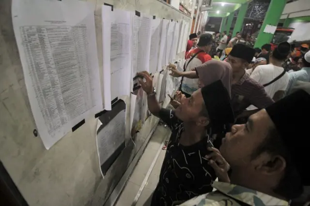 Las familias buscan una lista de las víctimas del derrumbe del edificio de la sala de oración del internado islámico Al Khoziny en el distrito de Buduran, Sidoarjo, Java Oriental, el lunes (29/09).