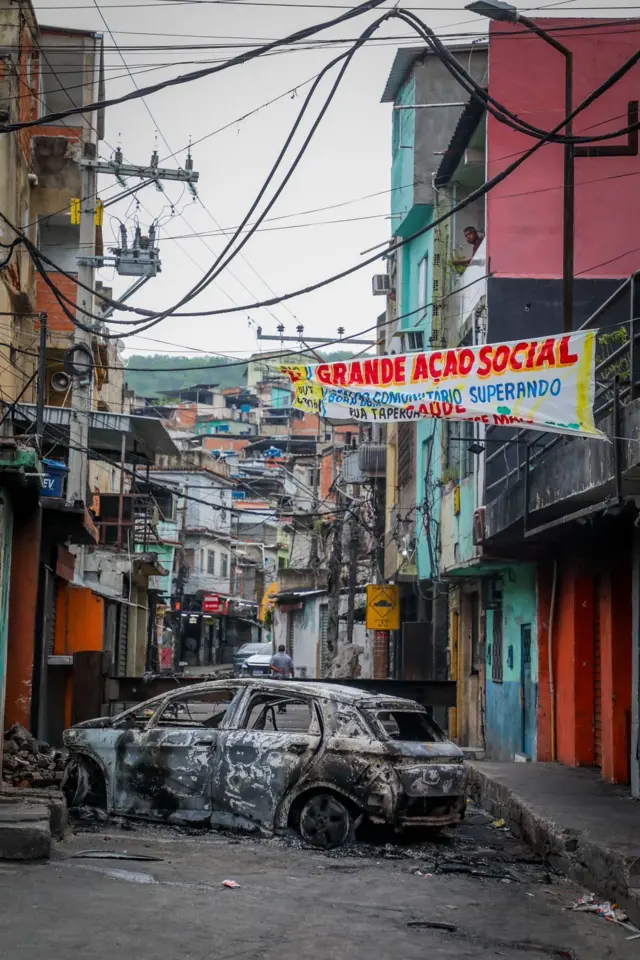 Carro queimado bloqueia passagem na favela
