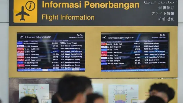 Calon penumpang pesawat melihat informasi jadwal keberangkatan pesawat di Terminal Internasional Bandara Internasional I Gusti Ngurah Rai, Badung, Bali, Rabu (13/11/2024).