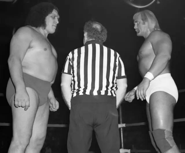 Black-and-white photo of Hulk facing Andre the Giant in a ring with a referee between them in 1980