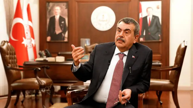 Milli Eğitim Bakanı Yusuf Tekin, bakanlıktaki makam odasında BBC Türkçe'nin sorularını yanıtlıyor. Tekin'in arkasında, Atatürk ve Cumhurbaşkanı Recep Tayyip Erdoğan'ın fotoğrafları görülüyor.