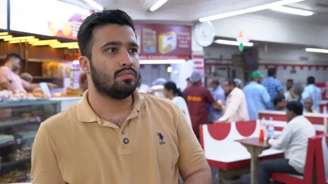 రెస్టారెంట్‌లో నిలుచున్న ఒక వ్యక్తి