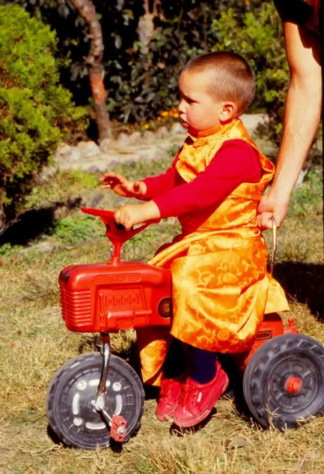 Osel Hita Torres de niño manejando un triciclo.