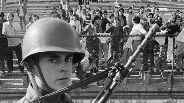 Soldado mira las graderías del Estadio Nacional de Chile.