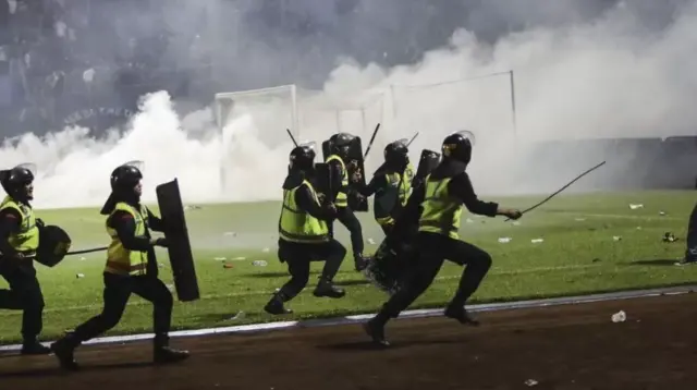 C﻿ảnh sát cố gắng ngăn chặn đám đông tràn xuống sân bóng