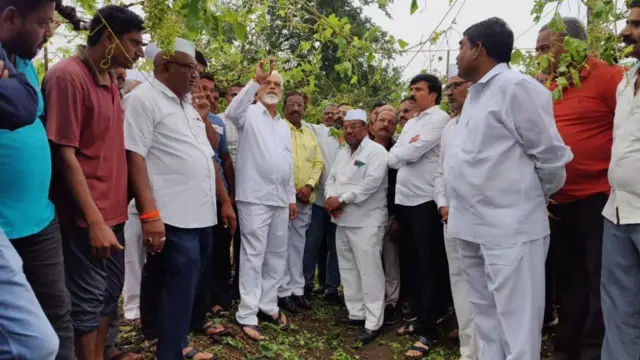 दादा भुसे नुकसानग्रस्त शेतीची पाहणी करताना.