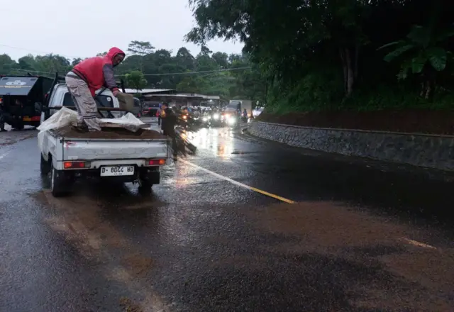 Proses penaburan pasir di lokasi kebocoran soda api di Bandung Barat.