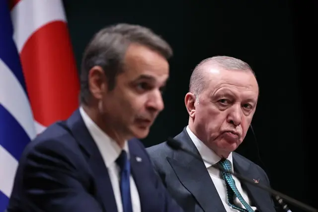Erdoğan dikkatle yanındaki siyasetçiyi dinliyor.