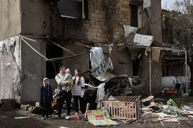 На фото - родина біля будинку після російського обстрілу Одещини