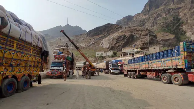 در تصویر چند لاری حامل محصولات تجارتی پاکستان به افغانستان را نشان می‌دهد که در متوقف هستند.