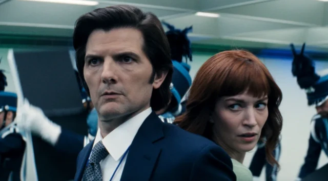 Un hombre, espalda con espalda con una mujer. Ambos miran en la misma dirección. 