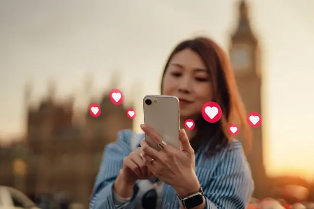 Young Asian woman using online dating app on smartphone in the city - stock photo