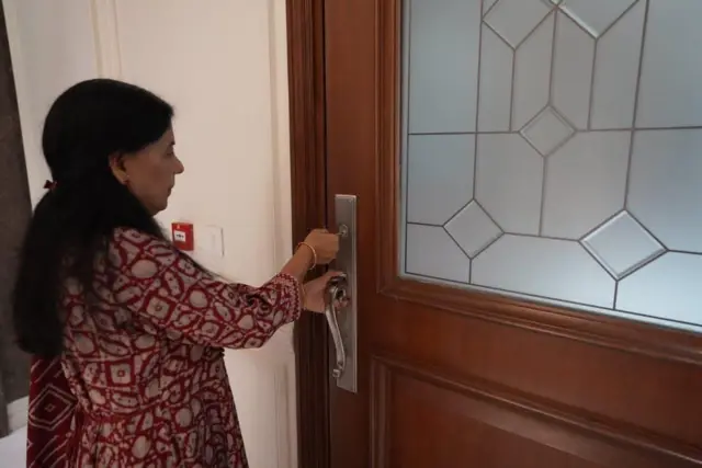 घर पर ताला लगाती सुनीता केजरीवाल