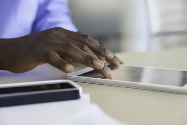 Un homme tape sur sa tablette