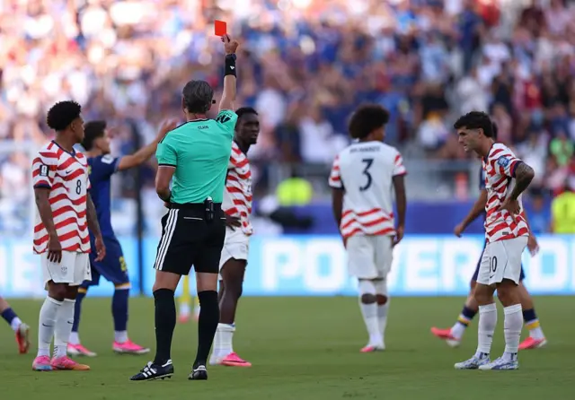 L'arbitre Raphael Claus adresse un carton rouge à Folarin Balogun (n° 20, États-Unis) pour une faute sur Tarik Muharemovic (n° 4, Bosnie-Herzégovine) lors du match des seizièmes de finale de la Coupe du Monde de la FIFA 2026 opposant les États-Unis à la Bosnie-Herzégovine, au San Francisco Bay Area Stadium, le 1er juillet 2026.