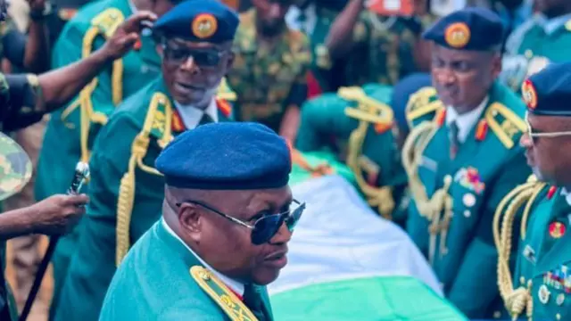 lokacin da ake sauke gawar a cikin mota, sojoji na riƙe da ita