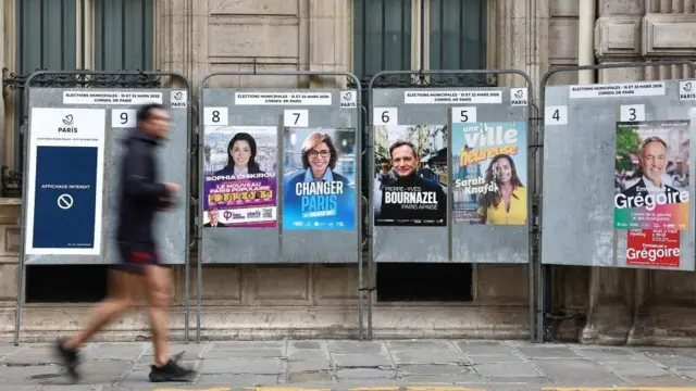 Biegacz mija plakaty wyborcze kandydatów na mera Paryża. Są nimi: Sophia Chikirou z partii La France Insoumise (pl. Francja Nieujarzmiona), Rachida Dati z prawicy, Pierre-Yves Bournazel z popierającej prezydenta Macrona centroprawicowej partii Horizons (pl. Horyzonty), Sarah Knafo z ultraprawicowej partii Reconquete (pl. Rekonkwista lub Odzyskanie), i socjalista Emmanuel Gregoire. 6 marca 2026 r. 
