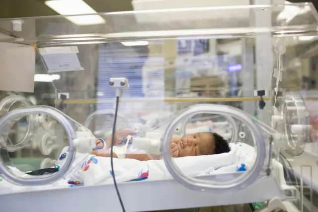 Un bebé recién nacido en una incubadora en un hospital