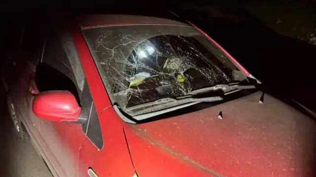 Червона машина з розбитим склом 
