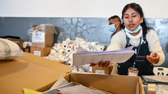 Una empleada electoral prepara una urna y materiales antes de las elecciones generales que se celebrarán el 17 de agosto en La Paz, Bolivia.