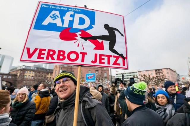 تظاهرکنندگان پلاکاردهای برای ممنوعیت حزب دست راستی آلترناتیو آلمان به دست گرفته‌اند