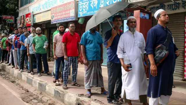  বিদ্যুতের প্রিপেইড মিটারের কার্ড রিচার্জ করার জন্য লাইনে অপেক্ষারত মানুষ। 