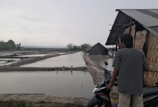 Warga di samping tambak garam di Dusun Bangkal, Pamekasan, Jawa Timur.