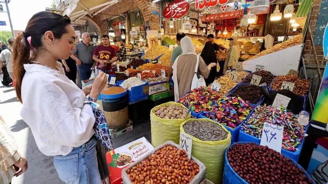 مردم در بازار بزرگ تهران در تاریخ ۳ ژوئن ۲۰۲۵ مشغول خرید هستند. دونالد ترامپ، رئیس جمهور آمریکا، در تاریخ ۲ ژوئن، اجازه غنیسازی اورانیوم به ایران تحت هرگونه توافق هستهای بین دشمنان را رد کرد -- در حالی که تهران از آنچه که پیگیری «صلحآمیز» سوخت برای تولید برق خواند، دفاع کرد.