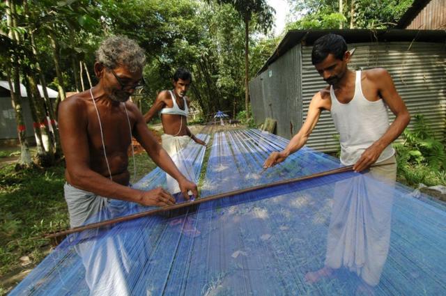 টাঙ্গাইল তাঁত পল্লীতে শাড়ি তৈরি করছেন কারিগররা। (ফাইল ছবি) 