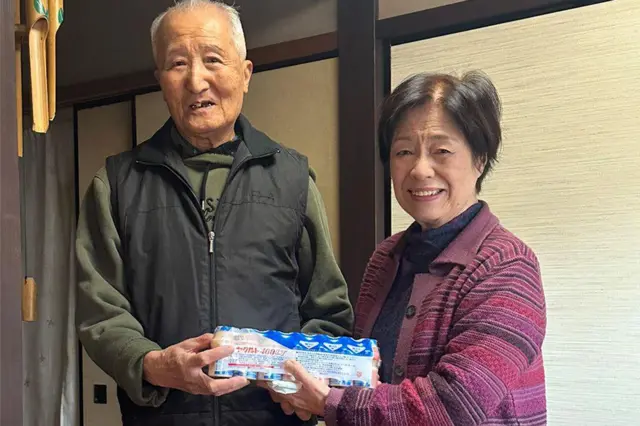 Dos personas mayores con yogures Yakult en la mano