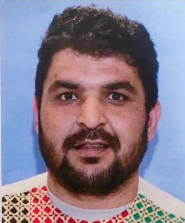 Rahmanullah Lakanwal'ın kafa fotoğrafında sakallı yüzü ve siyah saçları var. Yüzü toplu