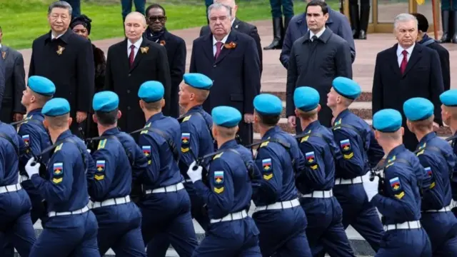 Военные на параде в честь Дня Победы маршируют мимо президентов.