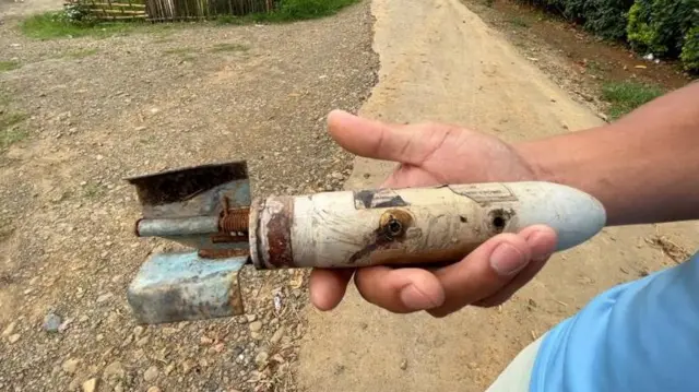 আরপিজি থেকে ছোঁড়া গ্রেনেড দেখাচ্ছেন গ্রামবাসীরা